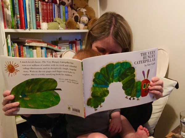 Mum and baby reading The Very Hungry Caterpillar by Eric Carle